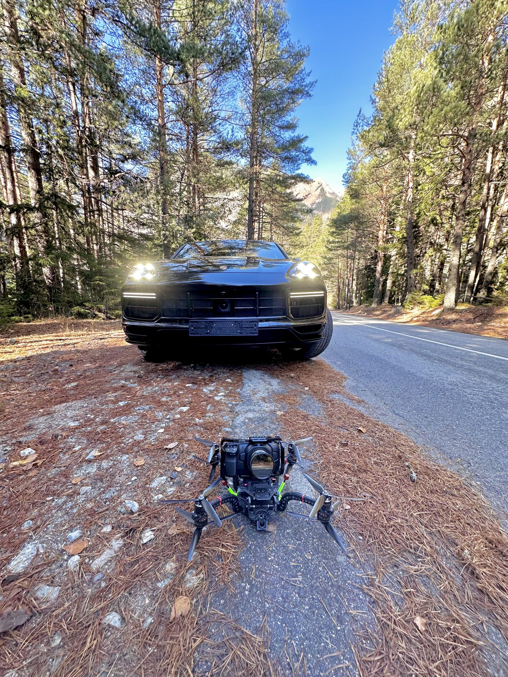 Cinelifter FPV-дрон перед Porsche на лесной дороге
