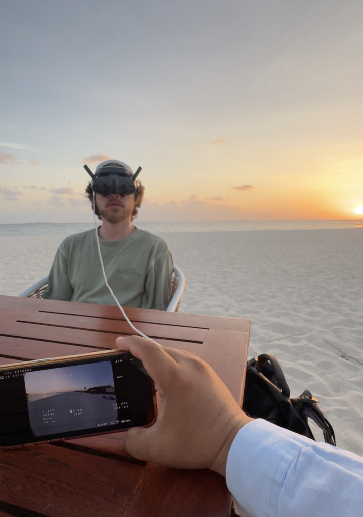 FPV-пилот в очках на пляже Maldives во время заката